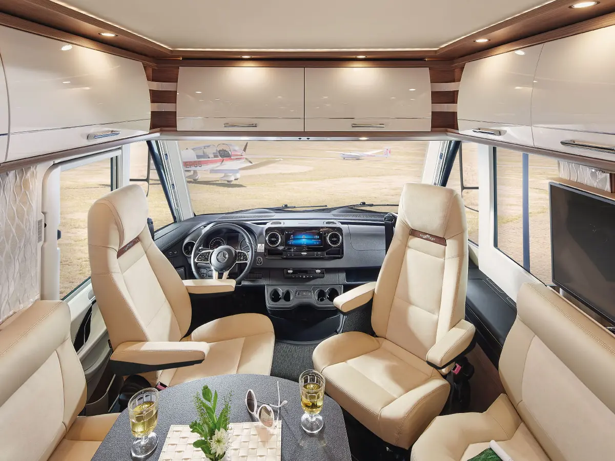Salon lumineux et sièges pivotants à bord d’un camping-car Carthago