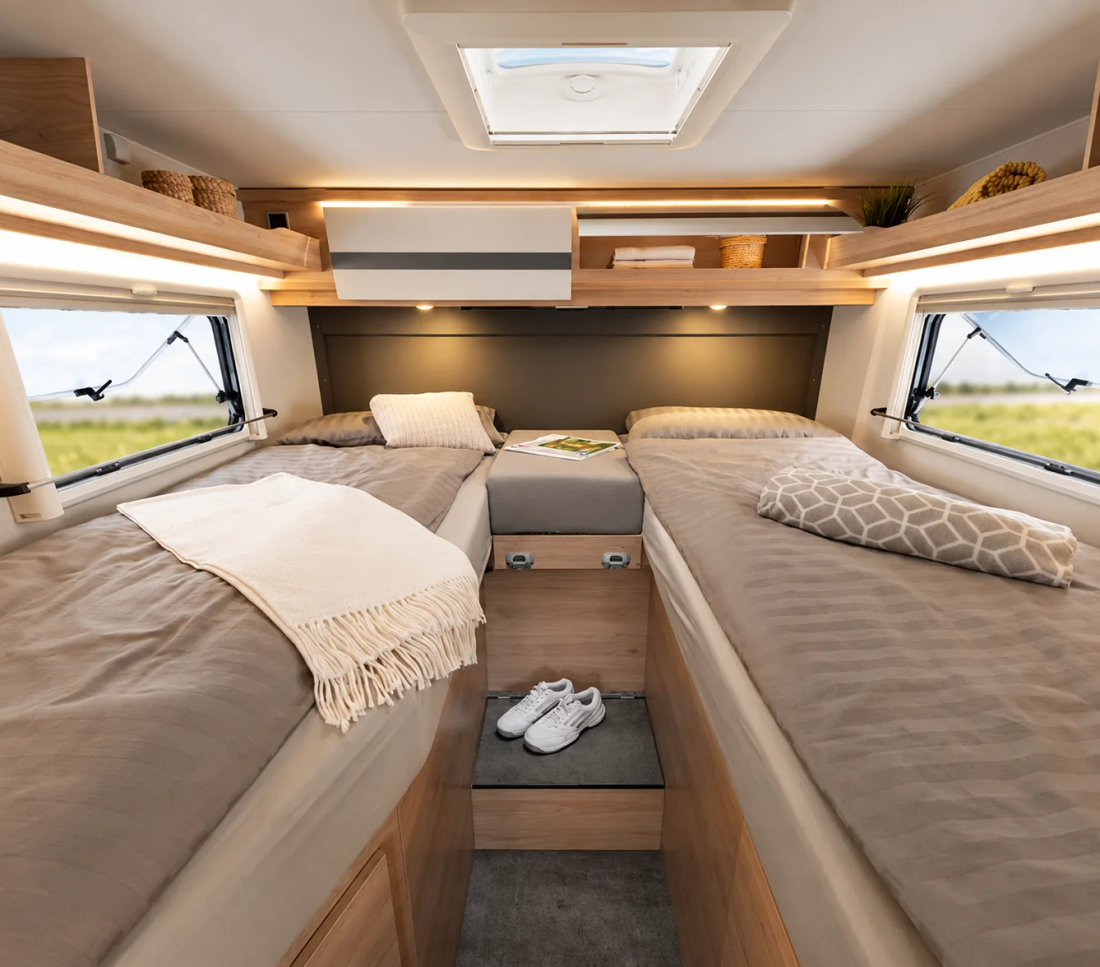 Lits jumeaux du Globebus I 6, avec marches centrales et rangements autour de la tête de lit