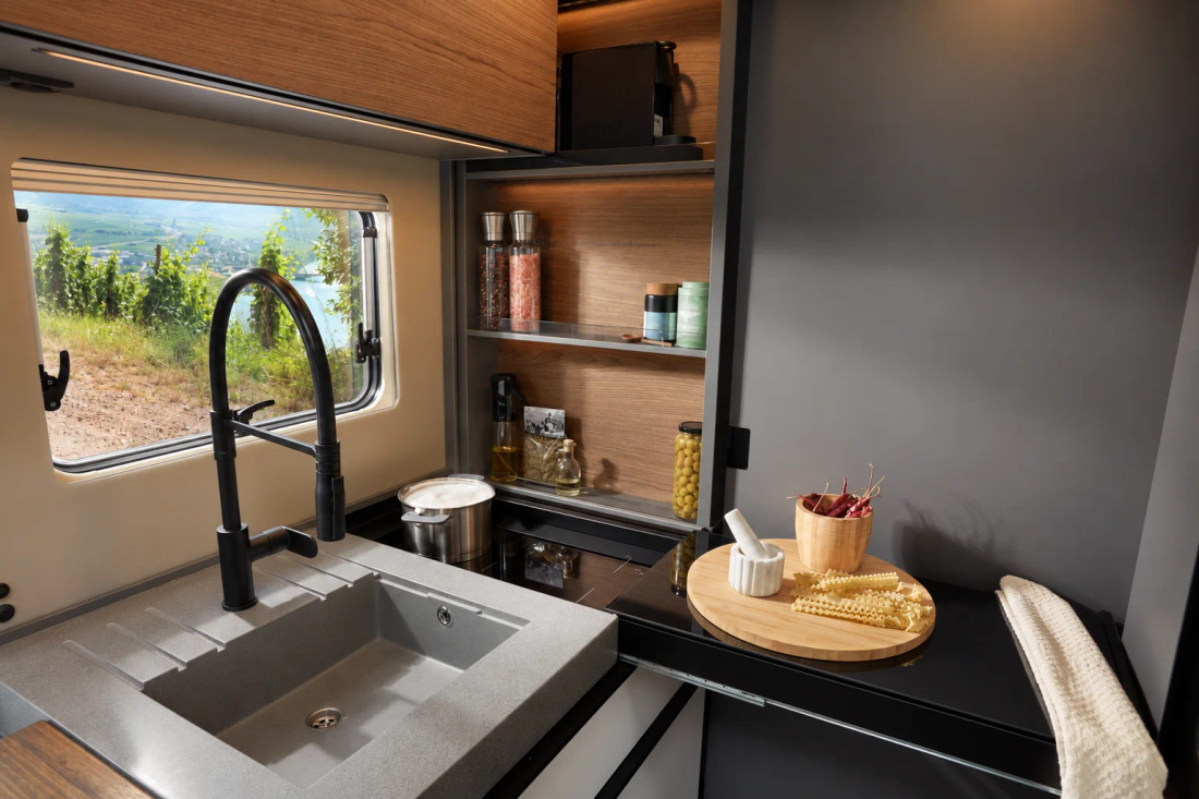 Cuisine de l'iSmove avec plan de travail, rangements ouverts et option de cuisson à induction