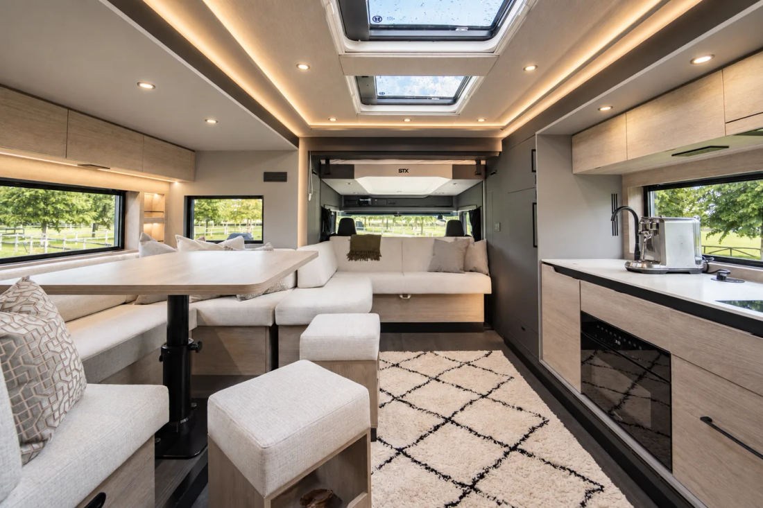 Salon du STX Scania 403 avec ses canapés clairs et ses grandes fenêtres